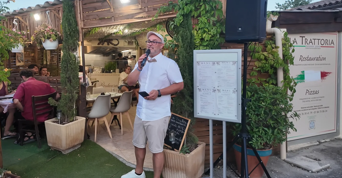Cédric chanteur au micro sur la terrasse de La Trattoria